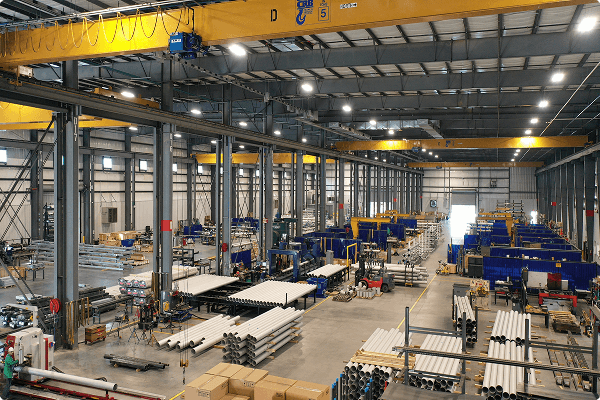 Interior of the UPI fabrication facility with piping and overhead cranes